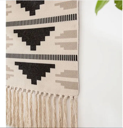 Woven blanket with geometric pattern and fringes on a white background