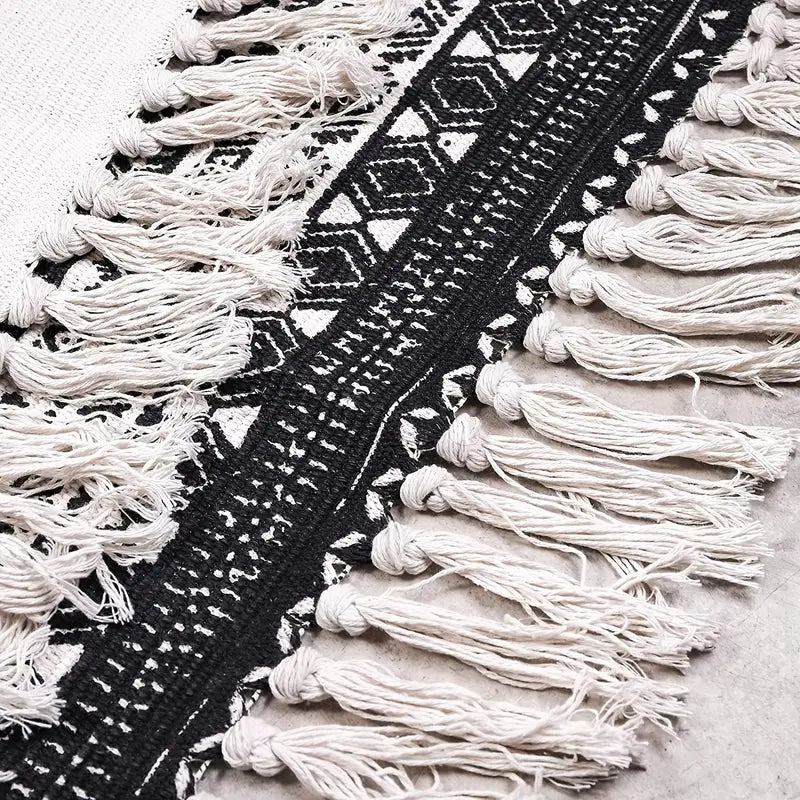 Close-up of a textured black and white rug with tassels