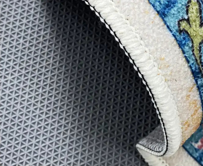 Close-up of a rug with geometric pattern and text about an environmentally friendly bottom.