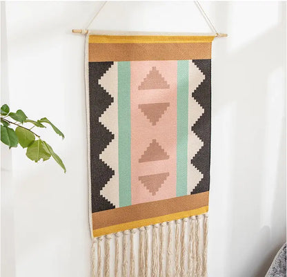 Woven wall hanging with geometric pattern on a white wall