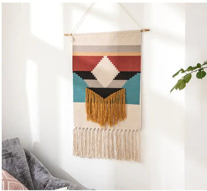 Colorful woven wall hanging with geometric pattern on a white wall.