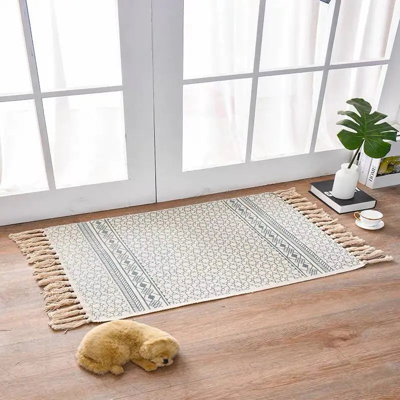 Decorative rug with tassels on a wooden floor in a bright room.