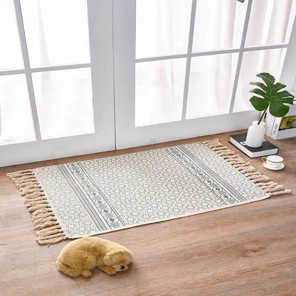 Decorative rug with tassels on a wooden floor in a bright room.