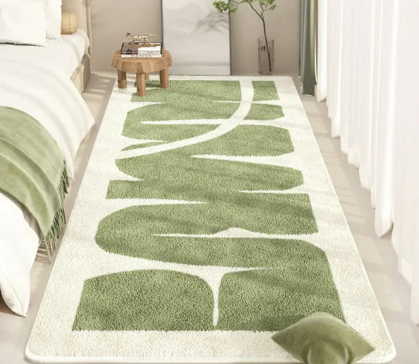 Green and white patterned rug on a wooden floor in a bedroom setting.