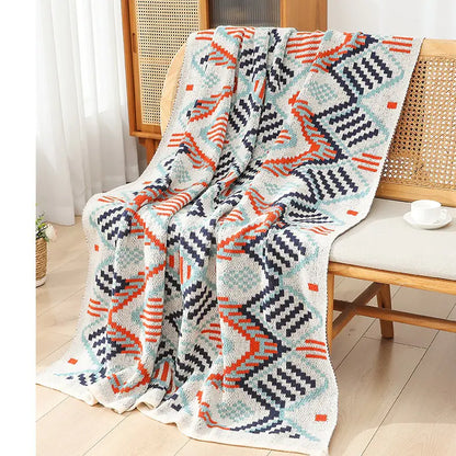 Geometric patterned blanket draped over a chair in a room with a light background