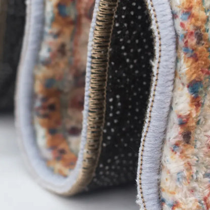 Close-up of a fabric product with floral and polka dot patterns on a neutral background