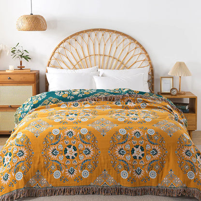 Yellow patterned comforter on a bed with a wooden headboard and side tables.