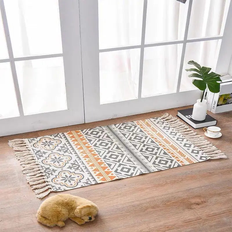 Patterned rug on a wooden floor with a small dog and decor items in the background.