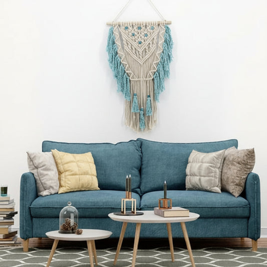 Blue sofa with decorative pillows in a living room setting with a macrame wall hanging.
