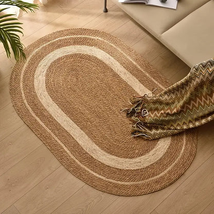 Round braided rug on a wooden floor with a patterned throw blanket.
